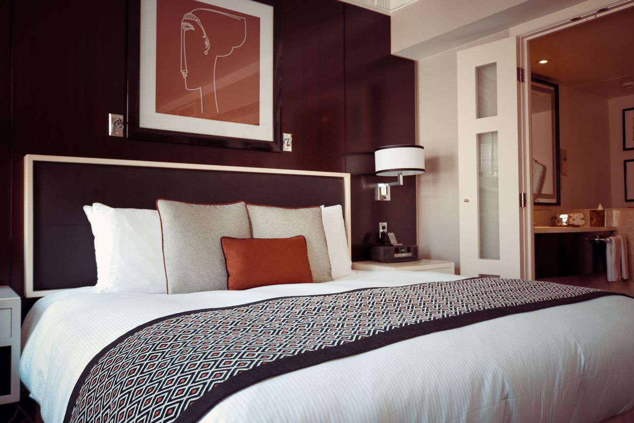 Hotelzimmer mit einladendem Bett und warmen Farbtönen